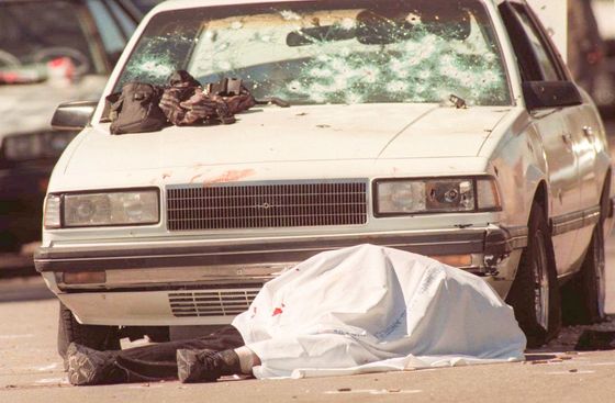 Tělo jednoho ze zastřelených lupičů ležící na místě přestřelky s policií. 28. 2. 1997, Los Angeles, USA.