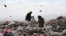 People collect recyclable cans and bottles at a garbage disposal site near Sanaa