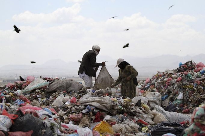 People collect recyclable cans and bottles at a garbage disposal site near Sanaa