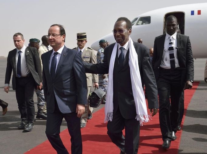 French President Francois Hollande (L) arrives with Mali's interim president Dioncounda Traore at the Bamako airport February 2, 2013. Malians chanting "Thank you, France!" mobbed Hollande on Saturday as he visited the desert city of Timbuktu, retaken from Islamist rebels, and pledged France's sustained support for Mali to expel jihadists. Hollande, accompanied by his ministers for defence, foreign affairs and development, was on a one-day trip to the Sahel nation to support French troops who in three weeks have ousted fighters allied with al Qaeda from Mali's main northern towns. REUTERS/Eric Feferberg/Pool (MALI - Tags: CONFLICT POLITICS) Published: Úno. 2, 2013, 5:10 odp.