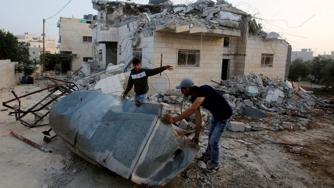 Palestinci zkoumají zbouraný dům rodiny jednoho z atentátníků.