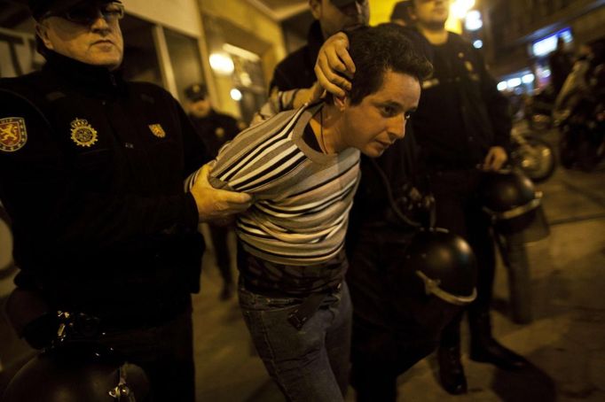 A picketer is arrested by riot police officers after trying to close a pub with others picketers at the start of a nationwide general strike in Malaga, southern Spain early November 14, 2012. Spanish and Portuguese workers will stage the first coordinated general strike across the Iberian Peninsula on Wednesday, shutting transport, grounding flights and closing schools to protest against spending cuts and tax hikes. REUTERS/Jon Nazca (SPAIN - Tags: BUSINESS EMPLOYMENT CIVIL UNREST POLITICS) Published: Lis. 14, 2012, 7:35 dop.