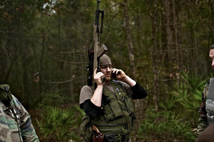 A member of the North Florida Survival Group takes a break from performing an enemy contact drill to call his wife during a field training exercise in Old Town, Florida, December 8, 2012.The group trains children and adults alike to handle weapons and survive in the wild. The group passionately supports the right of U.S. citizens to bear arms and its website states that it aims to teach "patriots to survive in order to protect and defend our Constitution against all enemy threats". Picture taken December 8, 2013. REUTERS/Brian Blanco (UNITED STATES - Tags: SOCIETY POLITICS) ATTENTION EDITORS: PICTURE 15 OF 20 FOR PACKAGE 'TRAINING CHILD SURVIVALISTS' SEARCH 'FLORIDA SURVIVAL' FOR ALL IMAGES Published: Úno. 22, 2013, 1:05 odp.