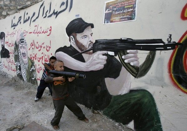Palestinský chlapec si hraje na vojáky