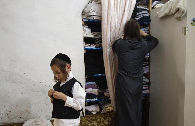 Shmuel Kreus (L), 5, dresses during his family's preparations for the Jewish Sabbath in Jerusalem's Mea Shearim neighbourhood June 29, 2012. The Kreus family are a member of Neturei Karta, a fringe ultra-Orthodox movement within the anti-Zionist bloc. The ultra-Orthodox Jews have gone from being a tiny minority in Israel's mostly secular society to its fastest-growing sector, now about 10 percent of the 7.8 million population. They are exempt from military duty in Israel but draft deferments and state subsidies for the ultra-Orthodox have become a divisive political issue in Israel, where the government must decide a new law by August to ensure more of them do military service. Picture taken June 29, 2012. REUTERS/Ronen Zvulun (JERUSALEM - Tags: RELIGION POLITICS SOCIETY MILITARY) ATTENTION EDITORS - PICTURE 12 OF 21 FOR PACKAGE "ISRAEL'S ULTRA-ORTHODOX". SEARCH "ULTRA-ORTHODOX" FOR ALL PICTURES Published: Čec. 6, 2012, 10:03 dop.