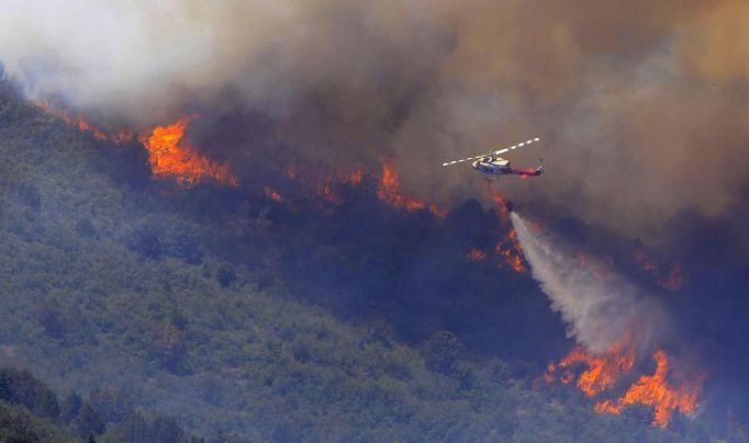 A fire fighting helicopter drops water over the Wood Hollow fire, north of Fairview, Utah, June 26, 2012. More than 500 structures have been threatened by the Wood Hollow fire, forcing up to 1,500 people from homes. REUTERS/George Frey (UNITED STATES - Tags: ENVIRONMENT DISASTER) Published: Čer. 26, 2012, 9:22 odp.