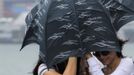 Women brave strong winds at the Tsim Sha Tsui district after Typhoon Vicente hit Hong Kong July 24, 2012. A severe typhoon hit Hong Kong on Tuesday, disrupting business across the financial hub, with offices and the stock market to remain closed for at least part of the morning after the city raised its highest typhoon warning overnight. REUTERS/Tyrone Siu (CHINA - Tags: ENVIRONMENT DISASTER BUSINESS) Published: Čec. 24, 2012, 3:06 dop.