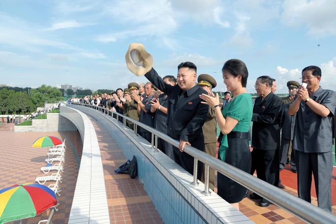 North Korean leader Kim Jong-Un and his wife Ri Sol-Ju attend the opening ceremony of the Rungna People's Pleasure Ground on Rungna Islet along the Taedong River in Pyongyang in this July 25, 2012 photograph released by the North's KCNA to Reuters on July 26, 2012.The Rungna People's Pleasure Ground has attractions such as a dolphinarium, a wading pool, a fun fair and a mini golf course, according to KCNA. REUTERS/KCNA (NORTH KOREA - Tags: POLITICS SOCIETY) FOR EDITORIAL USE ONLY. NOT FOR SALE FOR MARKETING OR ADVERTISING CAMPAIGNS. THIS IMAGE HAS BEEN SUPPLIED BY A THIRD PARTY. IT IS DISTRIBUTED, EXACTLY AS RECEIVED BY REUTERS, AS A SERVICE TO CLIENTS. NO THIRD PARTY SALES. NOT FOR USE BY REUTERS THIRD PARTY DISTRIBUTORS Published: Čec. 26, 2012, 3:28 dop.