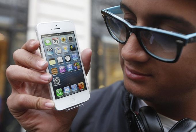 Anthony Fletch from Paris poses with his iPhone 5 after being the first customer at an Apple store in Paris September 21, 2012. Apple Inc's iPhone 5 hit stores around the globe on Friday, with fans snapping up the device that is expected to fuel a huge holiday quarter for the consumer giant. REUTERS/Jacky Naegelen (FRANCE - Tags: BUSINESS TELECOMS) Published: Zář. 21, 2012, 9:20 dop.