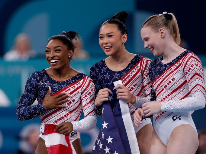 Americká gymnastka Simone Bilesová (vlevo) slaví s parťačkami zlato v soutěži družstev na OH 2024 v Paříži