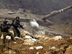 Izraelští vojáci utíkají do úkrytu, jejich tank zdemolovala střela ozbrojenců Hizballáhu.