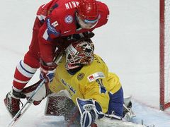 Ruský útočník Alexander Ovečkin (v červeném) atakuje gólmana Švédska Johana Backlunda.