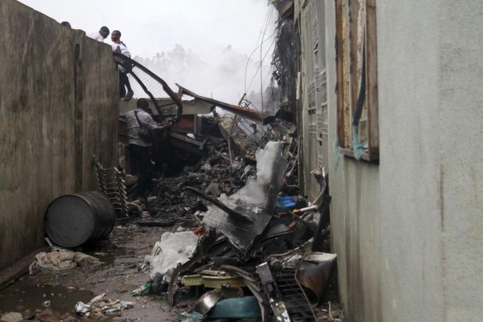 Wreckage is scattered in the compound of a building after a plane crashed into a neighbourhood in Ishaga district, an outskirt of Nigeria's commercial capital Lagos June 3, 2012. There were no survivors among the 147 people on board a domestic passenger aircraft that crashed in the Nigerian city of Lagos on Sunday, an official of the National Emergency Management Agency (NEMA), told Reuters. REUTERS/Akintunde Akinleye (NIGERIA - Tags: DISASTER TRANSPORT) Published: Čer. 3, 2012, 9:23 odp.