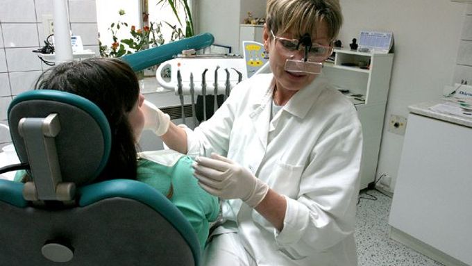 Mudr.Eva Sládková pečlivě prohlíží roentgenový snímek zubu pacientky.