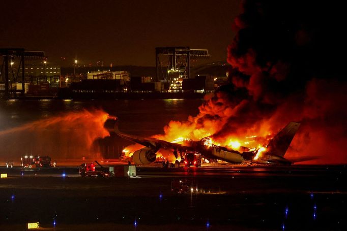 Hasiči zasahují u požáru letadla Airbus A350 společnosti Japan Airlines po srážce s letadlem pobřežní stráže na letišti Haneda v Tokiu, 2. ledna 2024.