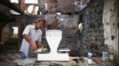 Nedzad Begovic looks at a scale in a restaurant in Potocari, near Srebrenica, July 6, 2012. Begovic and Slobodan Radakovic, both war survivors, make a living by putting together a restaurant selling roasted lamb. During the war, Bosnian Serb forces commanded by General Ratko Mladic killed up to 8000 Muslim men and boys in the Srebrenica area. Begovic lost 70 family members and Radakovic lost 10 family members. Picture taken July 6, 2012. REUTERS/Dado Ruvic (BOSNIA AND HERZEGOVINA - Tags: CONFLICT SOCIETY FOOD) Published: Čec. 8, 2012, 3:23 dop.