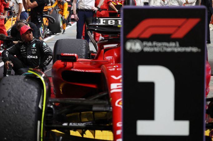 Lewis Hamilton si prohlíží vítězní Ferrari Carlose Sainz po VC Singapuru F1 2023