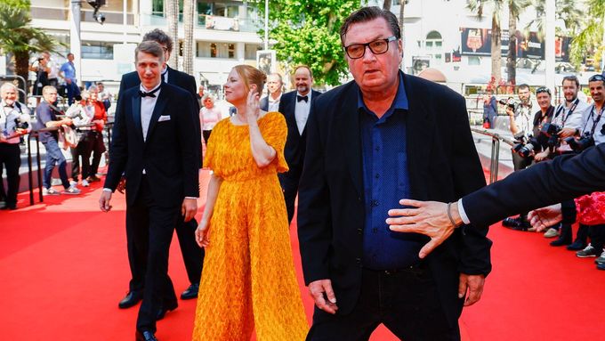 Ruka jednoho z pořadatelů festivalu v Cannes brání režisérovi Akimu Kaurismäkimu, aby hned opustil červený koberec.