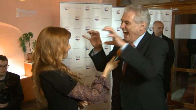 Kandidát na prezidenta Miloš Zeman předvádí aligátora, když odpovídá televizní reportérce na dotaz, zda vlastní mobilní telefon (leden 2013).