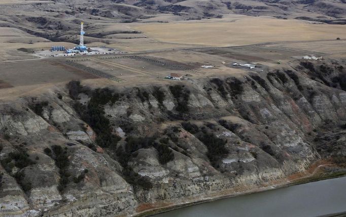 An oil drilling rig operates near homes, farm fields and the Missouri River outside Williston, North Dakota, October 19, 2012. Thousands of people have flooded into North Dakota to work in state's oil drilling boom. Picture taken October 19, 2012. REUTERS/Jim Urquhart (UNITED STATES - Tags: ENERGY ENVIRONMENT BUSINESS EMPLOYMENT) Published: Říj. 22, 2012, 1:40 odp.