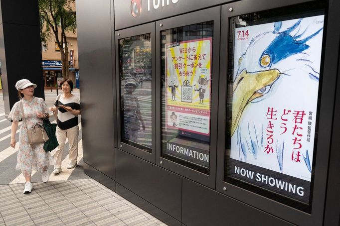 Na snímku z pátečního rána dvě Japonky v Tokiu procházejí okolo ručně nakresleného plakátu, který láká na nový film Hajaa Mijazakiho.