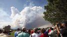 Evacuated residents and others listen to a briefing as smoke rises from the Waldo Canyon fire west of Colorado Springs, Colorado June 26, 2012. A fast-growing wildfire in Colorado forced 11,000 people from their homes at least briefly and threatened popular summer camping grounds beneath Pikes Peak, whose vistas helped inspire the patriotic tune "America the Beautiful". REUTERS/Rick Wilking (UNITED STATES - Tags: DISASTER ENVIRONMENT) Published: Čer. 26, 2012, 10:44 odp.