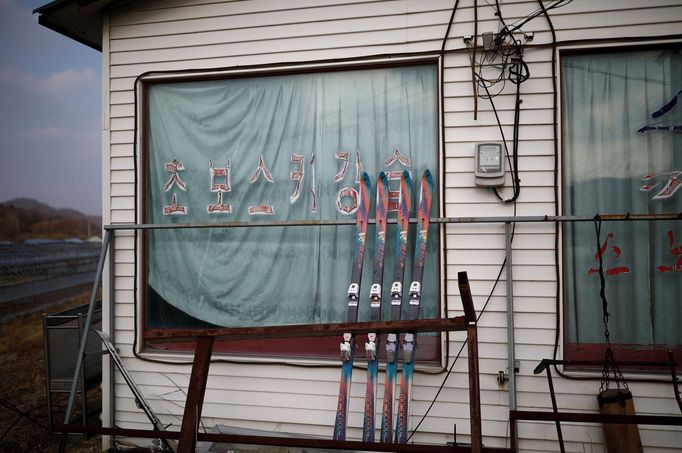 Pairs of skis are seen at an abandoned ski rental shop