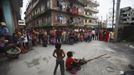 Nepalese people watch as Shivani Choudhary, 7, and her brother Drumpal, 11, perform tricks on a street in Kathmandu August 15, 2012. Shivani and her brothers Drumpal and Gchan, who came to Kathmandu from India 5 years ago, earn their living by performing tricks on the streets of Kathmandu. According to Drumpal, Shivani's older brother, they earn around $10 a day by performing tricks, which is not enough to feed their 10-member family living together in a small hut without a proper toilet or any basic needs. REUTERS/Navesh Chitrakar (NEPAL - Tags: SOCIETY IMMIGRATION POVERTY) Published: Srp. 15, 2012, 4:30 odp.