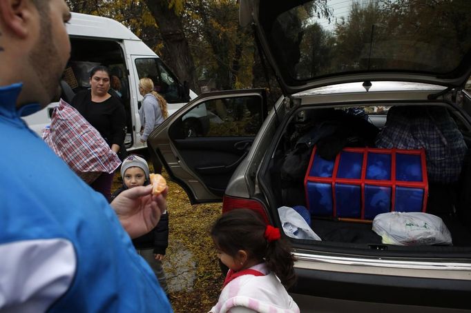 Members of the Gabarri-Valdes family distribute their belongings to different cars after a bulldozer demolished their home at the Spanish gypsy settlement of Puerta de Hierro, in the outskirts of Madrid November 20, 2012. Fifty-four families have been living in Puerta de Hierro, on the banks of the Manzanares river for over 50 years. Since the summer of 2010, the community has been subject to evictions on the grounds that the dwellings are illegal. Families, whose homes have been demolished, move in with relatives whose houses still remain while the debris keeps piling up around them as more demolitions take place. REUTERS/Susana Vera (SPAIN - Tags: CIVIL UNREST BUSINESS CONSTRUCTION) Published: Lis. 20, 2012, 5:12 odp.