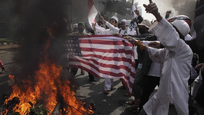 Indonesian Muslim protesters burn a mock U.S. flag during a protest in front of the U.S. embassy in Jakarta September 17, 2012. Indonesia police used teargas and water cannon on Monday to disperse hundreds of demonstrators who massed outside the U.S. embassy in Jakarta to protest against a film mocking the Prophet Mohammad. REUTERS/Beawiharta (INDONESIA - Tags: POLITICS CIVIL UNREST RELIGION) Published: Zář. 17, 2012, 10:17 dop.