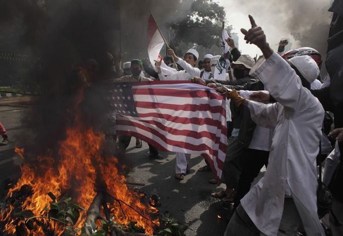 Indonesian Muslim protesters burn a mock U.S. flag during a protest in front of the U.S. embassy in Jakarta September 17, 2012. Indonesia police used teargas and water cannon on Monday to disperse hundreds of demonstrators who massed outside the U.S. embassy in Jakarta to protest against a film mocking the Prophet Mohammad. REUTERS/Beawiharta (INDONESIA - Tags: POLITICS CIVIL UNREST RELIGION) Published: Zář. 17, 2012, 10:17 dop.