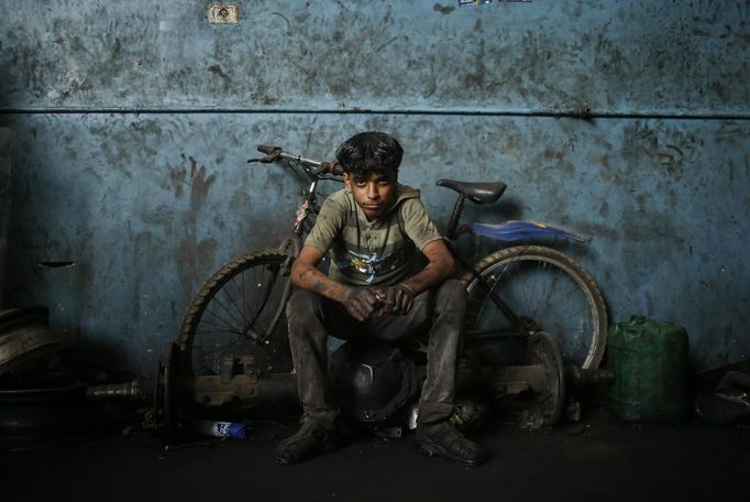 Palestinian Mohammed Jundeya, 17, poses for a photograph in a car repair garage in Gaza City May 30, 2013. Jundeya left school to work as an apprentice in the garage so that he could support his family's income. Apprentice mechanics earn around $100 per month, garage owners said. REUTERS/Mohammed Salem (GAZA - Tags: TRANSPORT SOCIETY EMPLOYMENT PORTRAIT) Published: Kvě. 30, 2013, 12:54 odp.