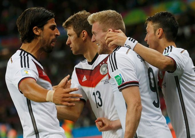 (L-R) Germany's Sami Khedira, Thomas Mueller and Mesut Ozil celebrate teammate Andre Schuerrle's (2nd R) goal against Algeria during extra time in their 2014 World Cup ro