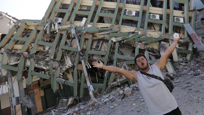 Obyvatel ekvádorského města Portoviejo gestikuluje před budovou, zřícenou při sobotním zemětřesení.