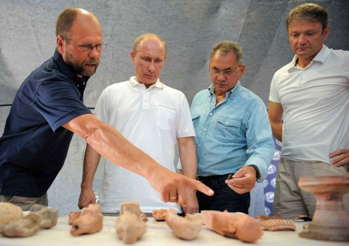 Ruský premiér Vladimir Putin (druhý zleva), ministr pro mimořádné situace Sergej Šojgu (druhý zprava) a krasnodarský guvernér Alexander Tkachev (vpravo) si prohlížejí archeologické relikty, které tým doktora Vladimira Kuznetzovova nalezl na vykopávkách u Tamaňského poloostrova v jižním Rusku.