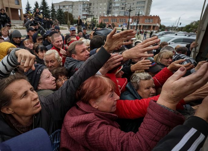 Lidé se mačkají u nákladního vozu s humanitární pomocí v osvobozené Balakliji.