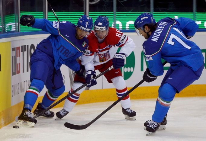 Jakub Petruzalek of the Czech Republic (C) battles for the puck with Italy's Marco Insam (L) and Davide Nicoletti (R) during the second period of their men's ice hockey W