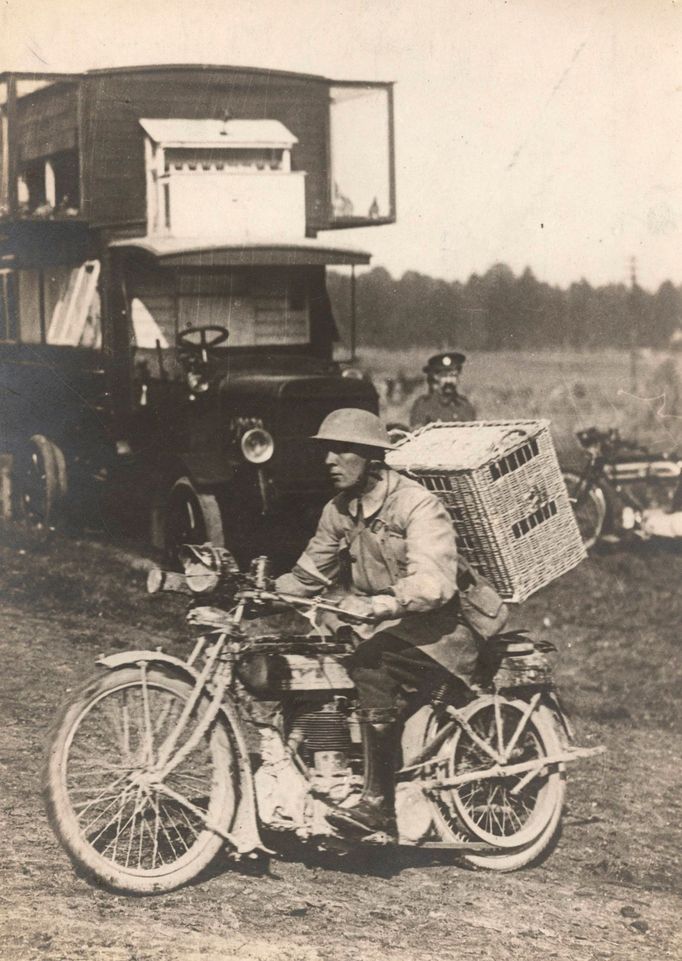 A British soldier rides a motorbike with a basket of pigeons on his back, on his way to delivering them to the frontline on the Western Front in this 1916 handout picture