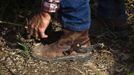 Alon, an Israeli cowboy, fixes his boot as he tends cattle on a ranch just outside Moshav Yonatan, a collective farming community, about 2 km (1 mile) south of the ceasefire line between Israel and Syria in the Golan Heights May 2, 2013. Cowboys, who have been running the ranch on the Golan's volcanic rocky plateau for some 35 years, also host the Israeli military, who use half of the cattle farm, 20,000 dunams (5,000 acres), as a live-fire training zone. Israel captured the Golan Heights from Syria in the 1967 Middle East war and annexed the territory in 1981, a move not recognized internationally. Picture taken May 2, 2013. REUTERS/Nir Elias (ENVIRONMENT ANIMALS SOCIETY) ATTENTION EDITORS: PICTURE 19 OF 27 FOR PACKAGE 'COWBOYS OF THE GOLAN HEIGHTS' SEARCH 'COWBOY GOLAN' FOR ALL IMAGES Published: Kvě. 29, 2013, 10:08 dop.