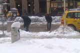 Úklid rozbředlého sněhu na parkovacích místech taxikářských aut na Václavském náměstí.