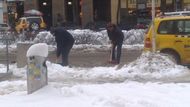 Úklid rozbředlého sněhu na parkovacích místech taxikářských aut na Václavském náměstí.