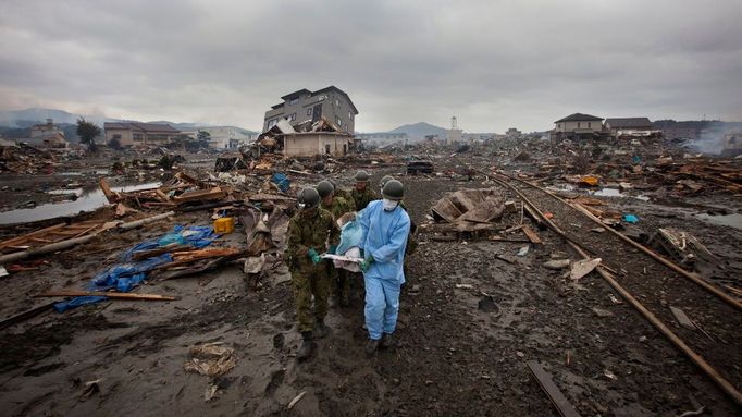 Tady bývalo japonské město Kesennuma... Záchranáři vyprostili tělo další z obětí. Snímek z úterý 15. března.