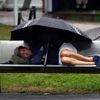 Tenisový fanoušek na US Open 2012 odpočívá během deště.