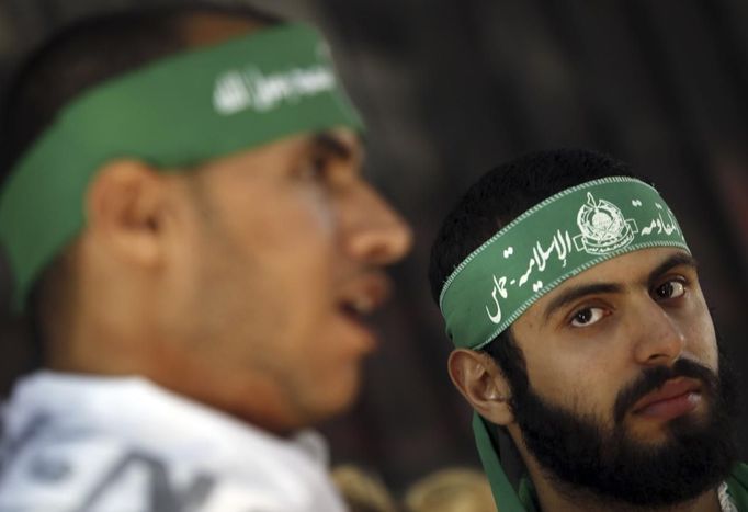 Palestinian (R) and Syrian men, who live in Egypt, take part in a protest against Israel's ongoing military operation in the Gaza Strip, in front of the Arab League offices in Cairo November 15, 2012. Egyptian President Mohamed Mursi condemned Israeli air strikes on the Gaza Strip as unacceptable on Thursday, in his harshest public criticism of Egypt's neighbour since taking office in June. The headband reads, "Islamic Resistance Movement, Hamas". REUTERS/Amr Abdallah Dalsh (EGYPT - Tags: POLITICS CIVIL UNREST) Published: Lis. 15, 2012, 3:55 odp.