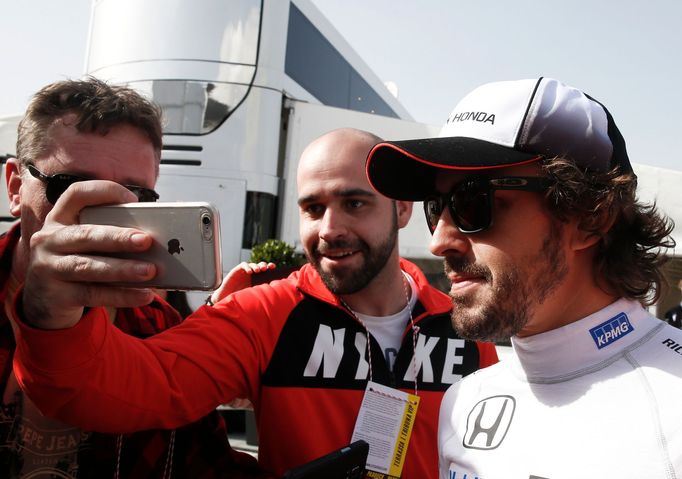 McLaren Formula One driver Fernando Alonso of Spain poses for a selfie with a supporter during the second testing session ahead of the upcoming season at the Circuit Barc