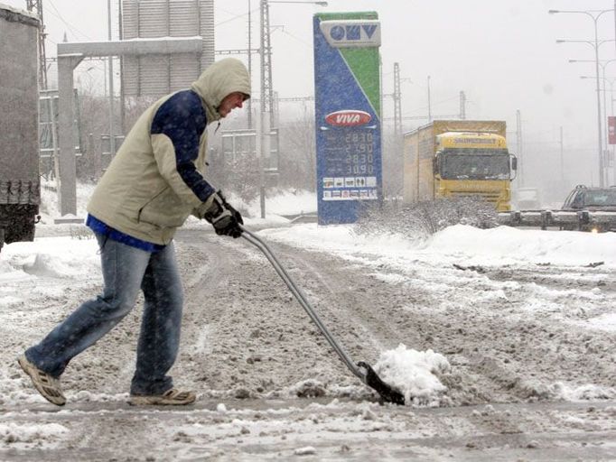 Na jižní spojce, u benzínové pumpy odklízejí sníh pro auta ručně