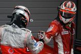 Piloti formule 1 Kimi Räikkönen z týmu Ferrari (vpravo) a Fernando Alonso z McLarenu si gratulují po Velké ceně Číny, kde se udrželi v boji o titul mistra světa.