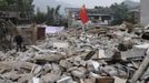 A man walks past a Chinese national flag planted on debris on the second day after an earthquake hit Longmen township of Lushan county, Sichuan province April 21, 2013. Rescuers struggled to reach a remote corner of southwestern China on Sunday as the toll of the dead and missing from the country's worst earthquake in three years climbed to 203 with more than 11,000 injured. The 6.6 magnitude quake struck in Lushan county, near the city of Ya'an in the southwestern province of Sichuan, close to where a devastating 7.9 temblor hit in May 2008 killing some 70,000. REUTERS/Stringer (CHINA - Tags: DISASTER) CHINA OUT. NO COMMERCIAL OR EDITORIAL SALES IN CHINA Published: Dub. 21, 2013, 7:10 dop.