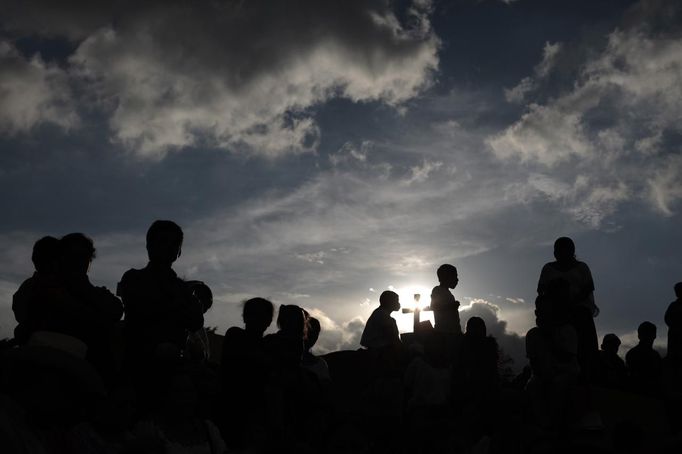 People wait for the coffins of 8-year-old Evelyn Yanisa Saquij Bin and 13-year-old Juan Armando Coy Cal, who were killed by a man in their classrooms, to arrive at the municipal cemetery in Tactic, in the Alta Verapaz region, some 189 km (117 miles) from Guatemala City, September 14, 2012. Angry villagers in Guatemala killed a man by setting fire to him after he hacked Saquij Bin and Armando Coy Cal to death with a machete in a school on September 12. The two children were buried today in a municipal cemetery. REUTERS/Jorge Dan Lopez (GUATEMALA - Tags: CRIME LAW SOCIETY) Published: Zář. 15, 2012, 5:05 dop.