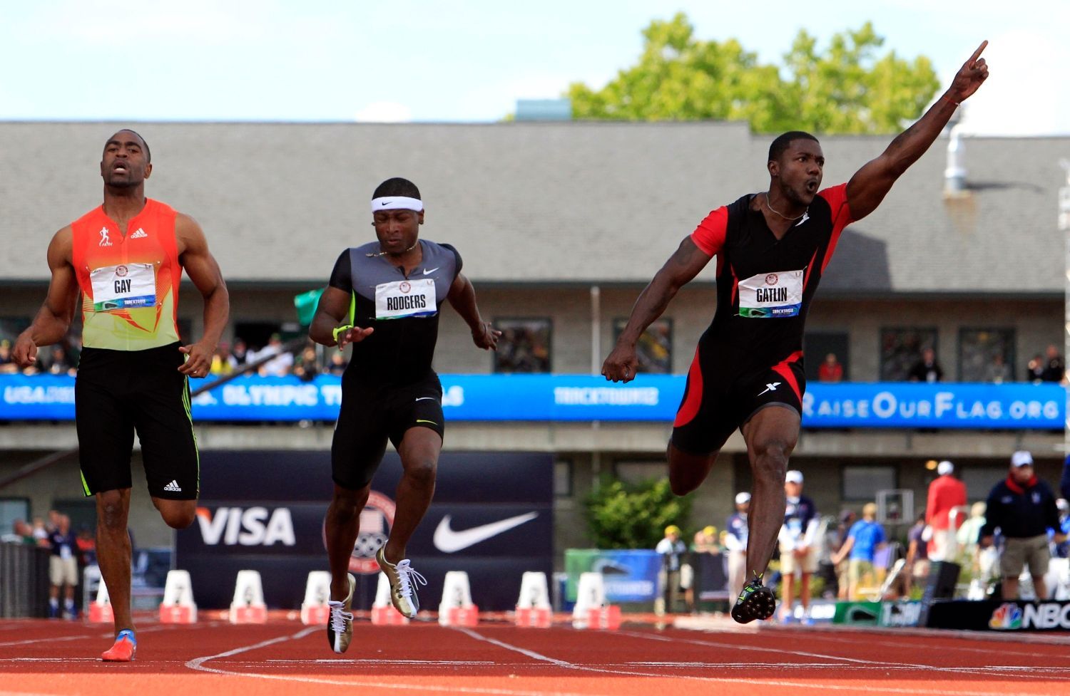 Sprinter Justin Gatlin vítězí během závodu na 100 metrů během americké kvalifikace v Eugene 2012. Vlevo běží Tyson Gay a uprostřed Michael Rodgers.